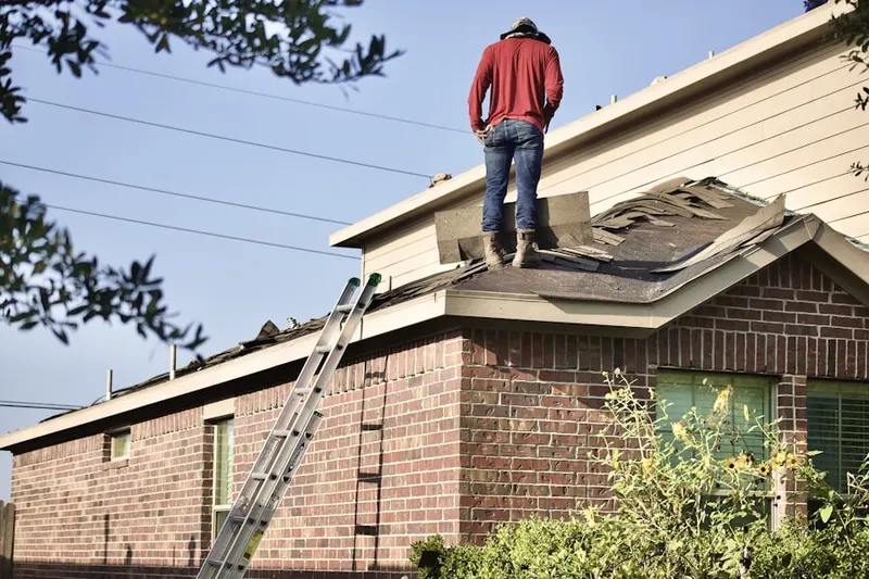 Professional roofer working on a residential roof in Hancock